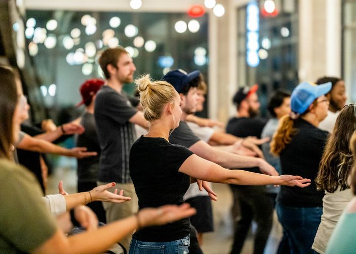 Group of people practicing gentle movements in a bright studio.